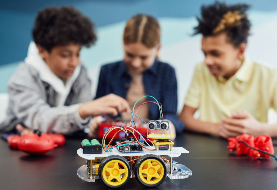 three students working on a robot