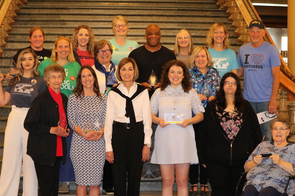 A group of individuals posed on a staircase after receiving an award