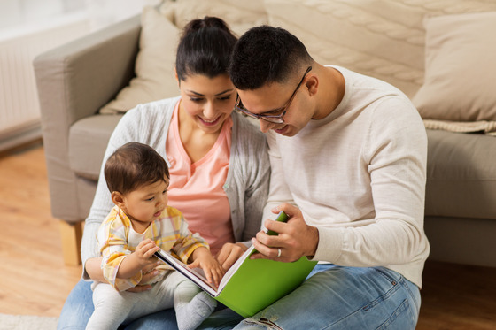 Two parents with their baby reading 