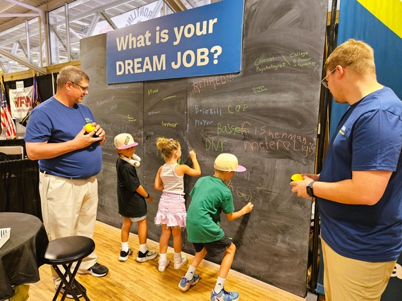 Children write on Dream Job chalkboard