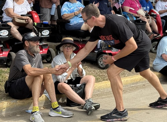 Giving challenge coin to veteran sitting on curb