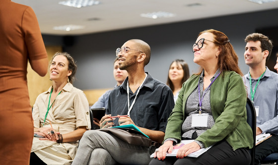 Group of people sitting in a circle listening to a speaker