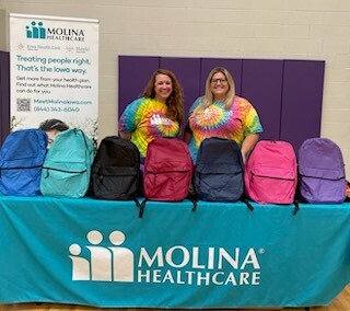 Molina staff handing out backpacks to students