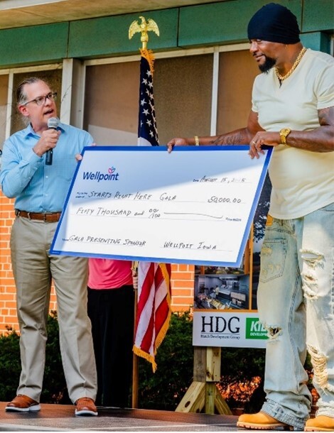 Two men holding a giant check from Wellpoint