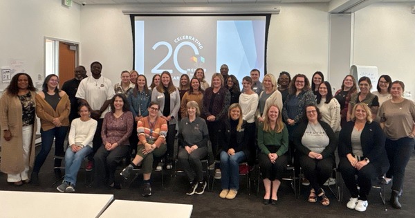 A group of about 35 people posing for a photo at a training
