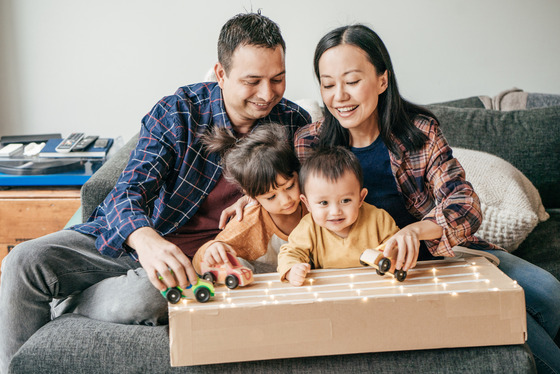 A mother and father with their two small children in a living room