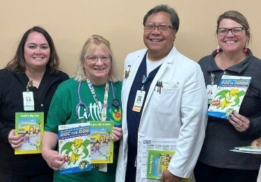 ITC staff posing with childrens books at an event 