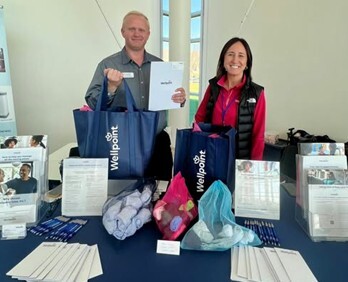 Wellpoint staff posing with promotional materials at a conference 