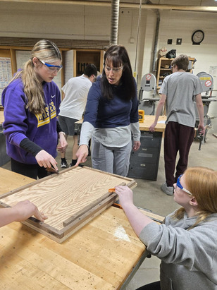Geometry teacher, Liz Tapper, working with students on the production of the bat house kits. 