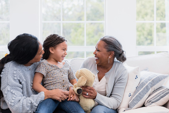 Family of three laughing on the couch