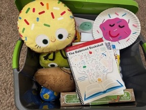 A picture of a box of colorful toy and book donations 