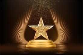 Gold star award on a stage with glowing lights and sparkles, symbolizing achievement, recognition, or excellence.
