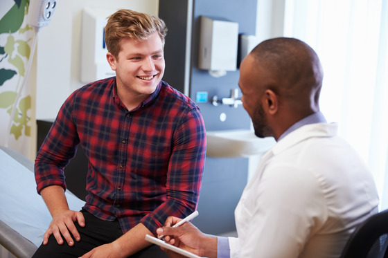 A man speaking with his healthcare provider in a doctor's office 