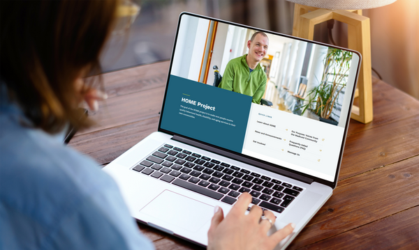 A person viewing the HOME project website on a laptop