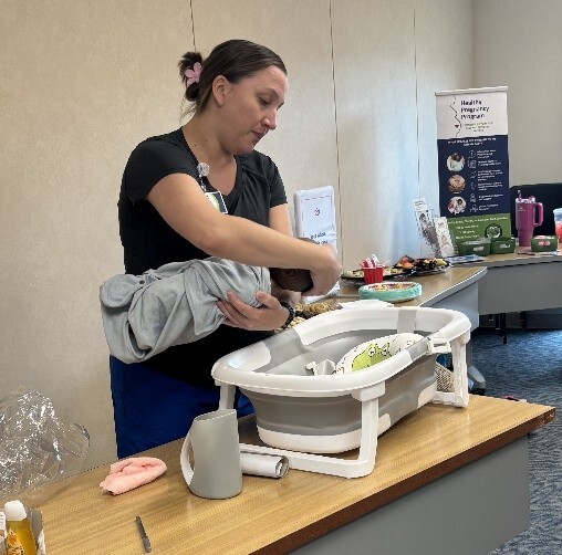 A woman at a table practicing infant care