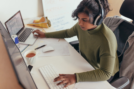 Female Programmer at her desk working on a laptop