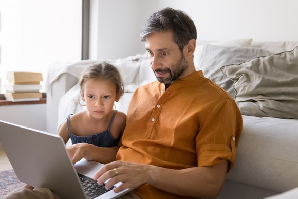  Mid aged father and daughter on laptop
