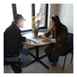 Health navigator, Vivian, sitting with a client to help complete an application for assistance.