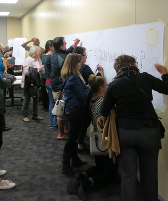 Attendees draw on posters during the community Climate Action Meeting in Iowa City.