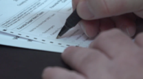 Voter ID Law - hand and marking pen over ballot