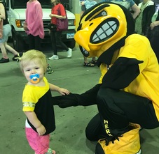 A child poses with Herky at the Farmers' Market