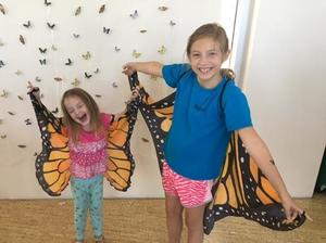 Two girls at the Iowa City Monarch festival pose wearing monarch wings