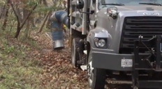 City truck vacuuming leaves on a curb