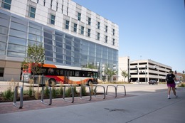 A City bus is shown traveling down a Downtown street. 