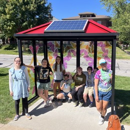 Teen volunteers in the bus shelter they helped decorate on North Van Buren Street