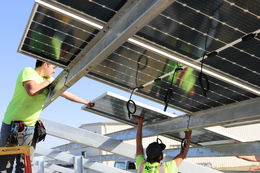 workers are pictured installing solar panels at the airport