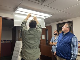 Staff at Our Redeemer show a LED light fixture