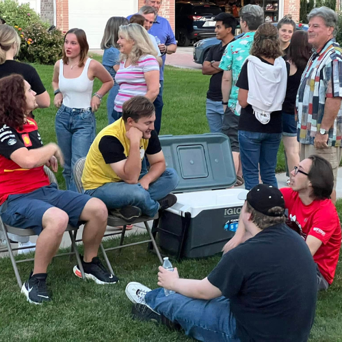 OutAbout event in Draper, Utah shows young men chatting while sitting on a lawn