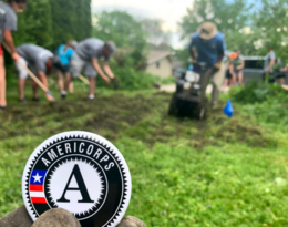 AmeriCorps logo in a photo of people gardening