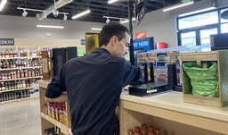 Image of Ed Teets installing network equipment at Idaho State Liquor store in Eagle, ID