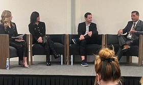 Four people in a panel presentation sitting on stage 