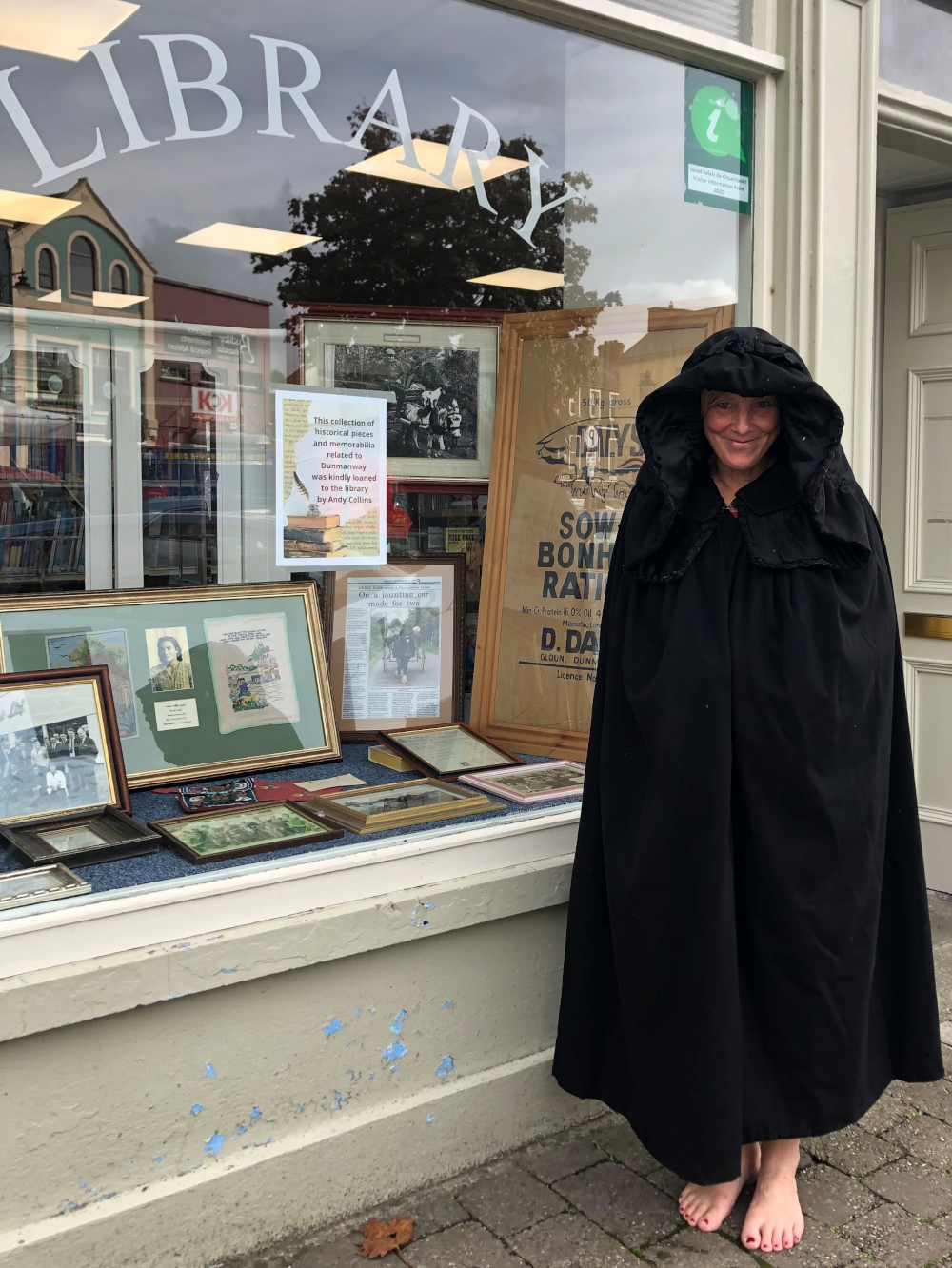 Woman wearing a big black cloak outside Dunmanway Library