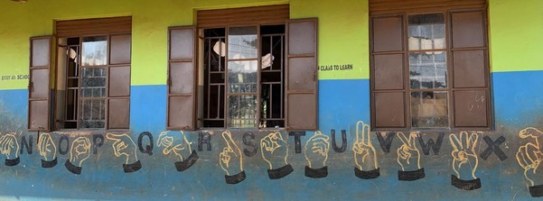 The classroom in the Kamurasi Demonstration School in Masindi Municipality, Uganda, with the Ugandan Sign language alphabet drawn on the wall.