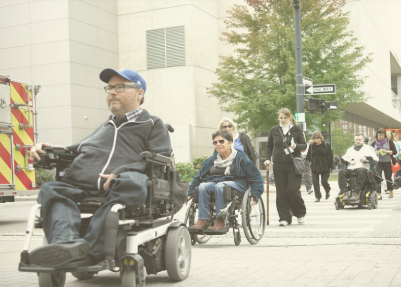 People using wheelchairs crossing an intersection