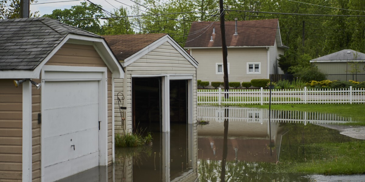 Flooded water ponds around two garages in backyard