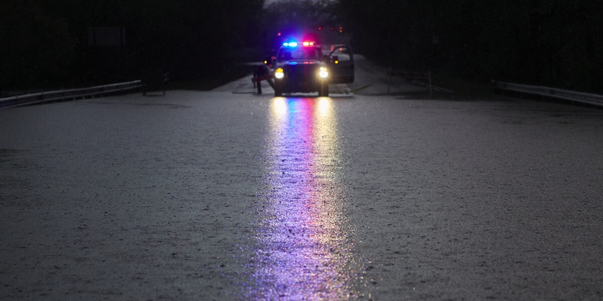 Emergency vehicle lights reflect off flooded road