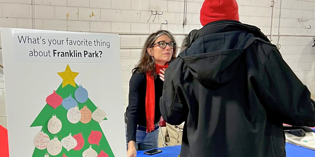 Visitor at CMAP Table at Franklin Park community event featuring holiday decorations