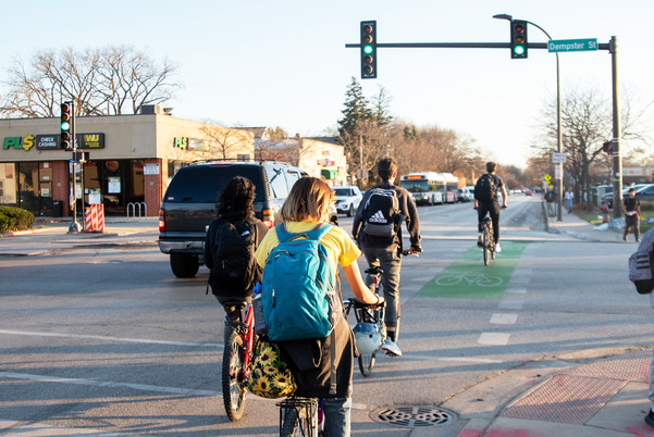 Photograph of people biking on a marked green bike lane through an intersection