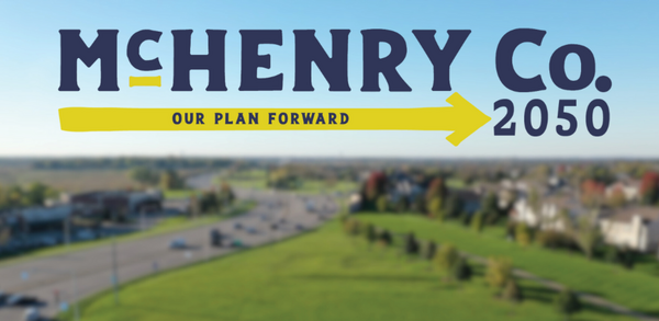 Blurred image of an intersecting road with text overlay 'McHenry County 2050, Our Plan Forward'
