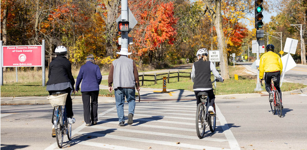 Five people in a crosswalk entering cook county forest preserve