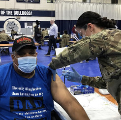 Cook County resident receives COVID-19 vaccine from an Illinois National Guard member. 