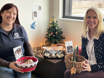 Victoria Kappa and Laura Winnie holding presents made by children at the Family Center for shelter animals.