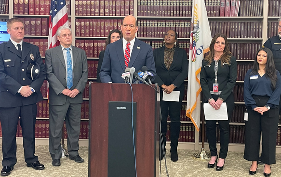 DuPage County State's Attorney Robert Berlin standing at a podium during a press conference.