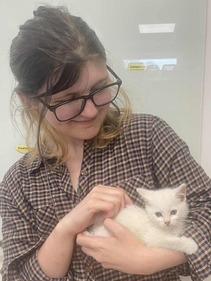 Kota holding a white kitten