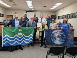 DuPage County Environmental Committee, Kay McKeen, and West Chicago hold the water quality and earth flags