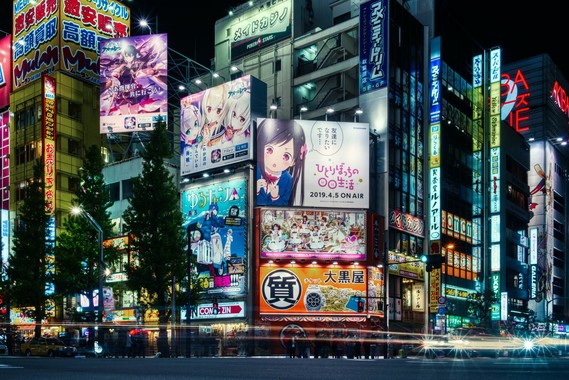 picture of a Japanese street corner with anime billboards